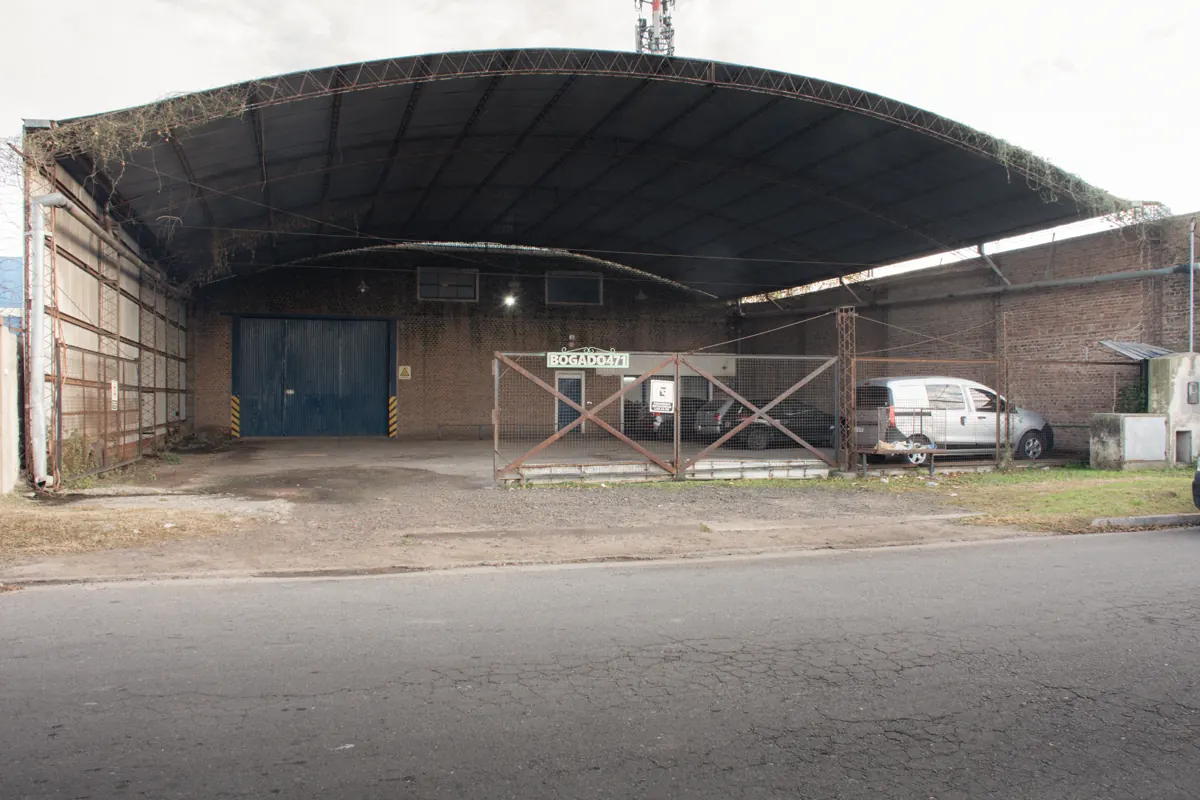 Frente del taller: galpón de techo curvo con portón azul en Coronel Bogado 471